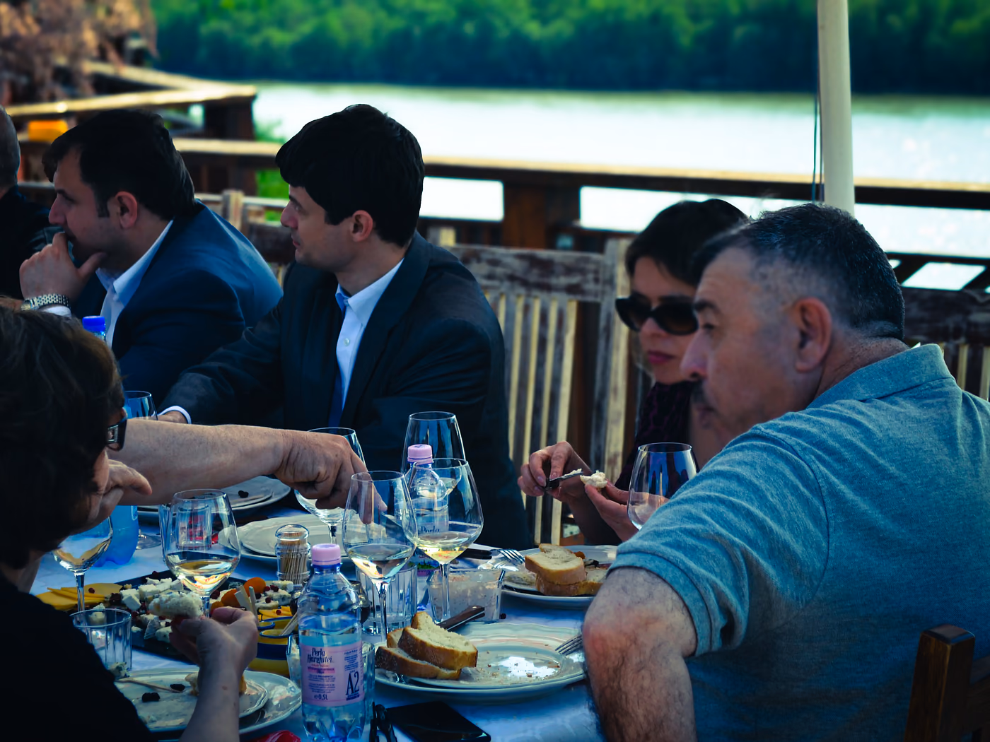 Outdoor table by the Danube with wine and people gathered together